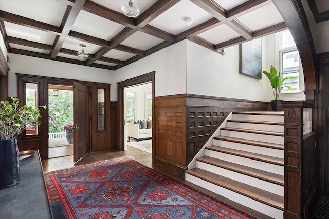 151 Salisbury Rd, Brookline, MA 02445 - foyer entrance featuring coffered ceiling, beamed ceiling, a wainscoted wall, wood finished floors, and stairs