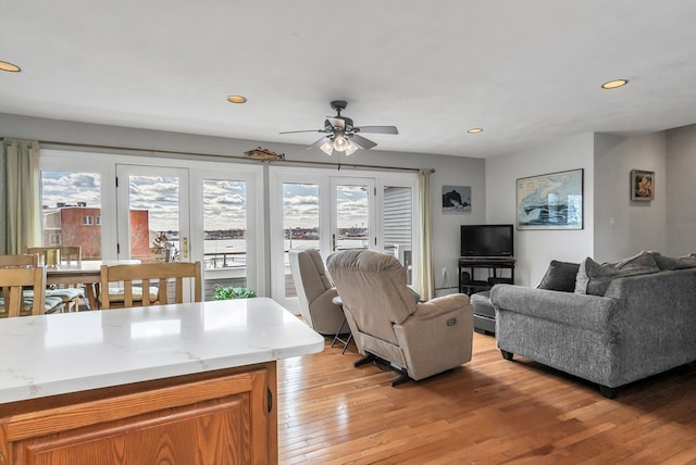 living area with a ceiling fan, recessed lighting, and light wood-style flooring