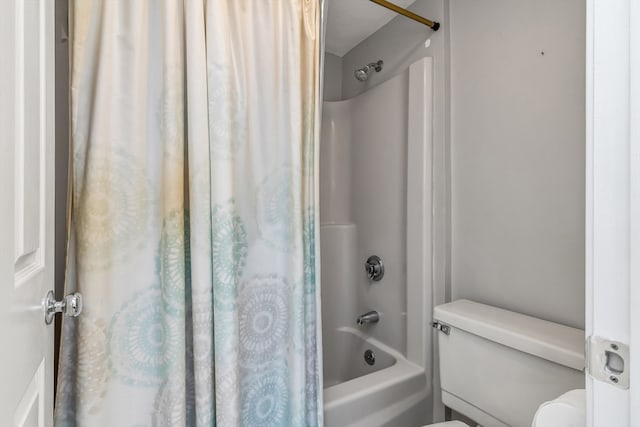 bathroom featuring toilet and shower / bath combination with curtain