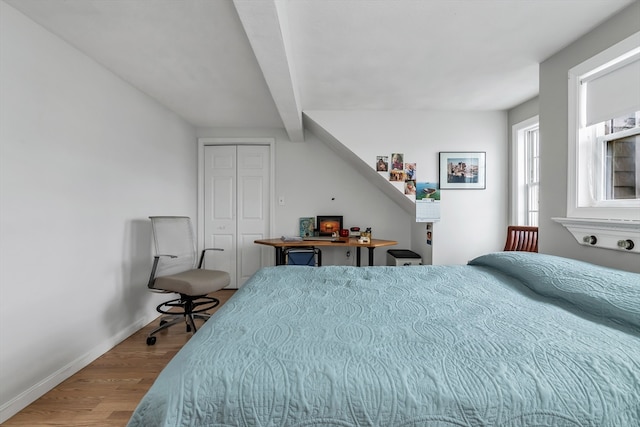 bedroom with a closet, baseboards, and wood finished floors