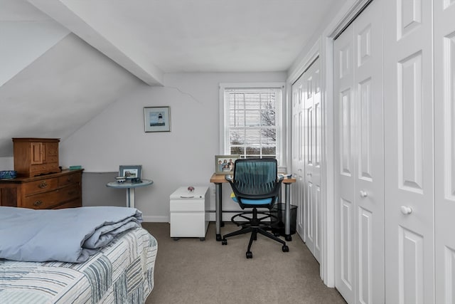 carpeted bedroom with lofted ceiling with beams, two closets, and baseboards