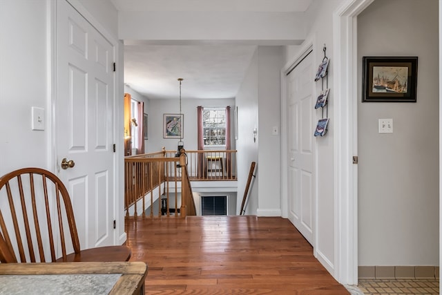 foyer featuring baseboards, visible vents, and wood finished floors