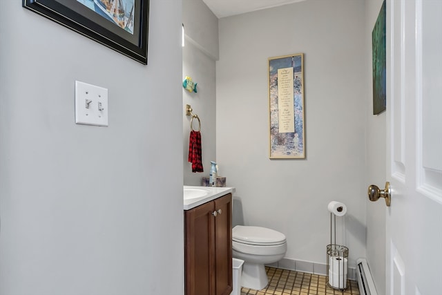 half bathroom featuring toilet, a baseboard heating unit, vanity, baseboards, and tile patterned floors