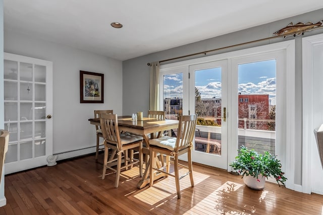 dining room with baseboard heating and hardwood / wood-style flooring