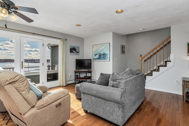 living room featuring baseboards, hardwood / wood-style flooring, a baseboard radiator, stairway, and recessed lighting