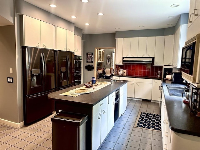 201 Main Rd, Williamsburg, MA 01039 - kitchen with black appliances, dark countertops, light tile patterned flooring, an island with sink, and decorative backsplash