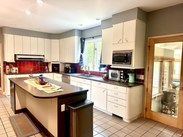 201 Main Rd, Williamsburg, MA 01039 - kitchen with dark countertops, appliances with stainless steel finishes, under cabinet range hood, light tile patterned floors, and tasteful backsplash