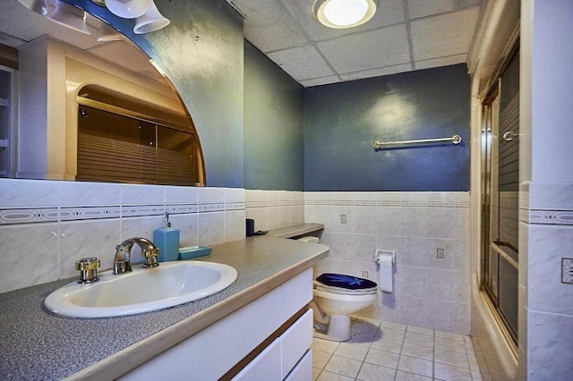 201 Main Rd, Williamsburg, MA 01039 - full bath featuring toilet, vanity, tile walls, tile patterned flooring, and bath / shower combo with glass door