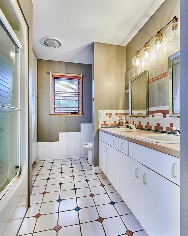 201 Main Rd, Williamsburg, MA 01039 - bathroom featuring double vanity, toilet, and tasteful backsplash