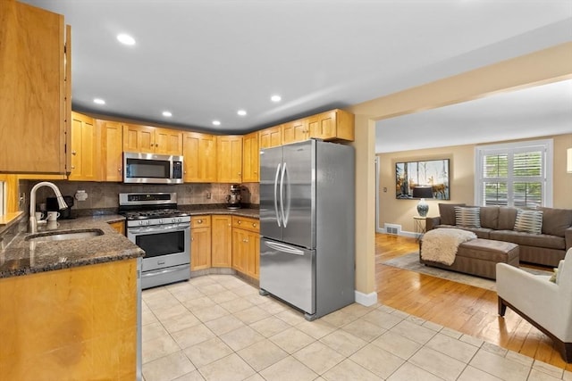 9 Oak St, Wayland, MA 01778 - kitchen with appliances with stainless steel finishes, a sink, light tile patterned floors, open floor plan, and decorative backsplash