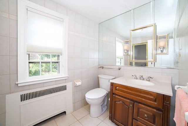 493 Salisbury St, Worcester, MA 01609 - bathroom with radiator, tile walls, vanity, toilet, and tile patterned floors