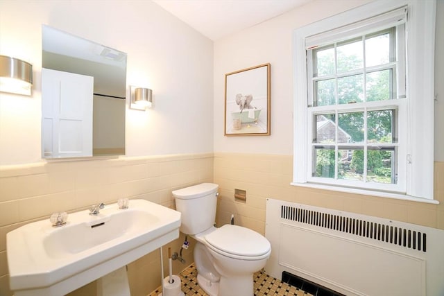 493 Salisbury St, Worcester, MA 01609 - bathroom featuring radiator, tile walls, toilet, healthy amount of natural light, and a wainscoted wall