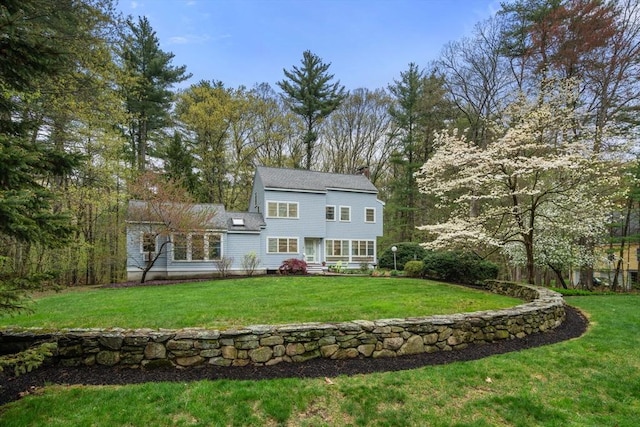 rear view of house with a yard and a chimney