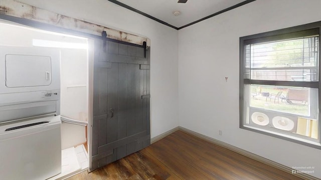 1-3 River Pl, Methuen, MA 01844 - unfurnished bedroom featuring stacked washer and clothes dryer, a barn door, wood finished floors, a closet, and crown molding
