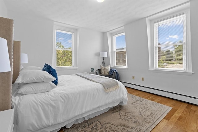 39 School St Unit 39, Brookline, MA 02446 - bedroom with wood finished floors, multiple windows, and a baseboard radiator