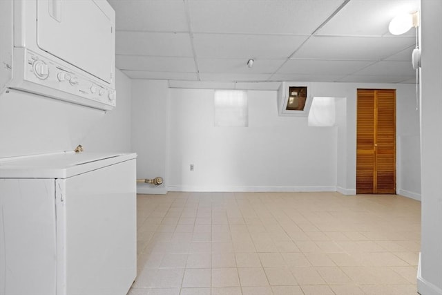 39 School St Unit 39, Brookline, MA 02446 - finished basement with stacked washer / dryer, a drop ceiling, baseboards, and light tile patterned flooring