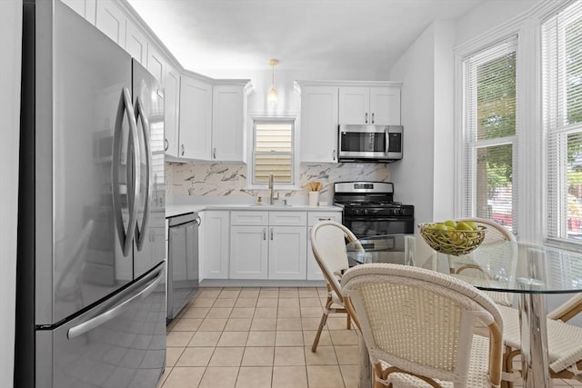 39 School St Unit 39, Brookline, MA 02446 - kitchen featuring stainless steel appliances, a sink, tasteful backsplash, and white cabinetry