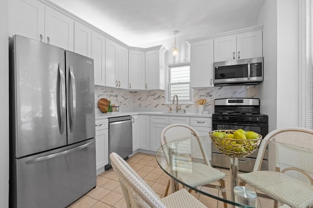 39 School St Unit 39, Brookline, MA 02446 - kitchen featuring appliances with stainless steel finishes, a sink, light countertops, tasteful backsplash, and white cabinets