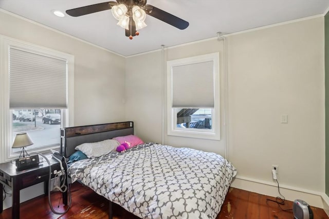 bedroom featuring crown molding, wood finished floors, and multiple windows