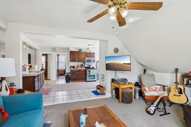 living area with light carpet, a ceiling fan, vaulted ceiling, and light tile patterned floors