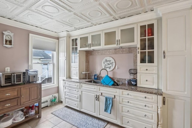 mudroom featuring baseboard heating, an ornate ceiling, a sink, and light tile patterned floors