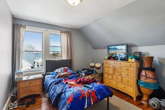 bedroom with dark wood finished floors and vaulted ceiling