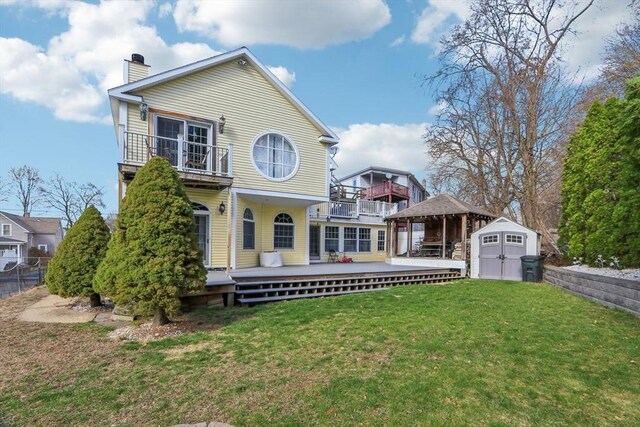 view of front of property with a gazebo, a balcony, a front lawn, an outbuilding, and a storage unit