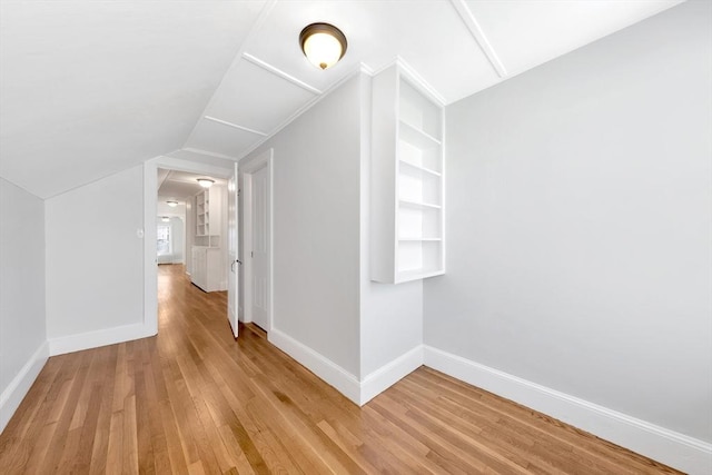 additional living space with built in shelves, hardwood / wood-style floors, and vaulted ceiling