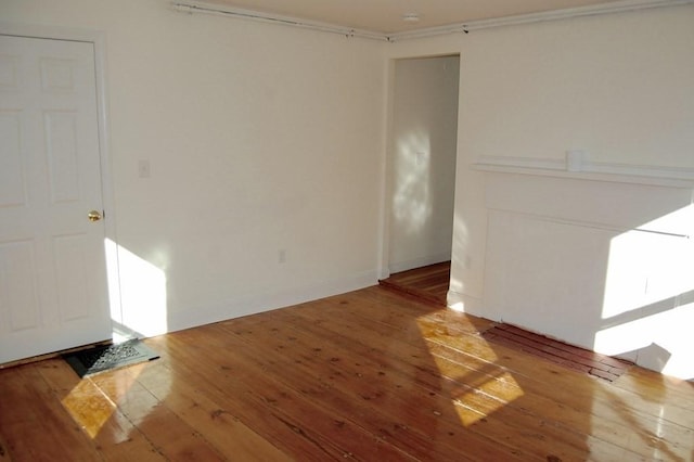 unfurnished room featuring hardwood / wood-style flooring and baseboards