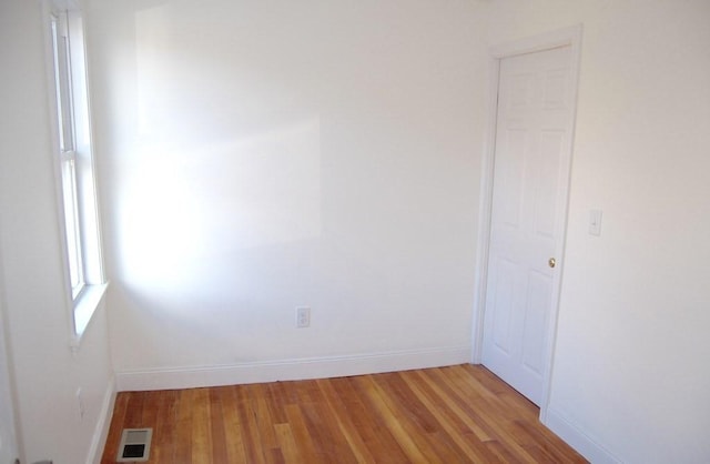 unfurnished room with light wood finished floors, baseboards, and visible vents