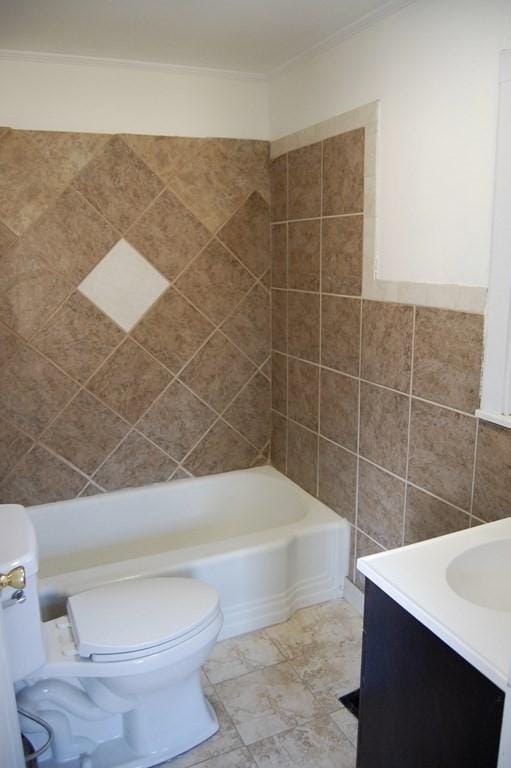full bath featuring toilet, tile walls, a bath, and vanity