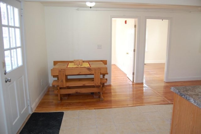 dining space featuring a healthy amount of sunlight, light wood-type flooring, and baseboards