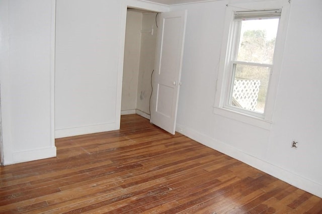 unfurnished room featuring wood-type flooring and baseboards
