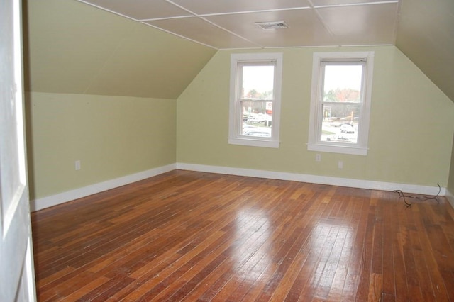 additional living space featuring lofted ceiling, wood-type flooring, visible vents, and baseboards