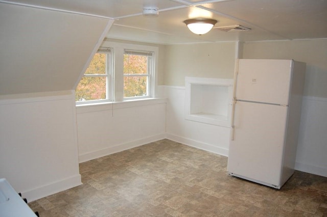 additional living space with wainscoting, visible vents, and tile patterned floors