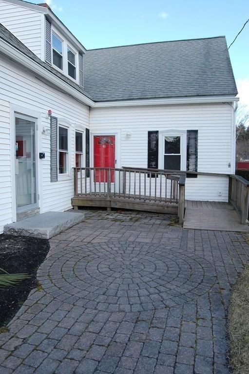 exterior space featuring a patio, roof with shingles, and a wooden deck