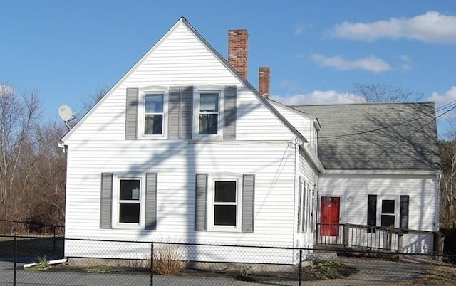 view of front of home with a fenced front yard and a chimney