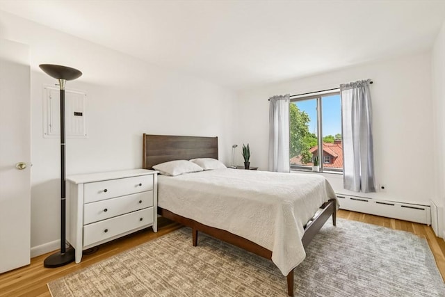 128 Pleasant St Unit 407, Arlington, MA 02476 - bedroom with a baseboard heating unit, light wood-style flooring, and electric panel