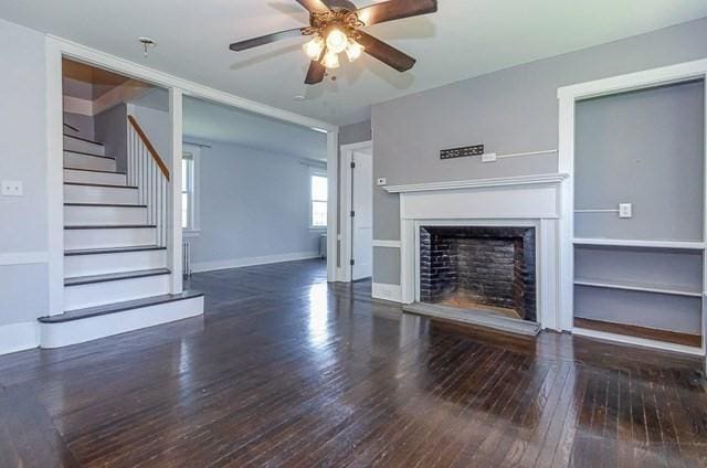 17 Harrison St, New Bedford, MA 02740 - unfurnished living room with hardwood / wood-style floors, a ceiling fan, stairs, a fireplace with raised hearth, and baseboards