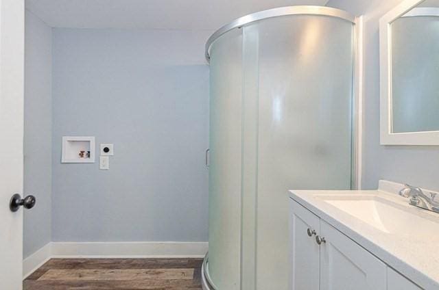 17 Harrison St, New Bedford, MA 02740 - bathroom featuring wood finished floors, vanity, baseboards, and a shower stall