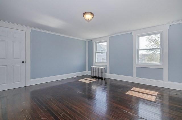 17 Harrison St, New Bedford, MA 02740 - unfurnished room with radiator heating unit, wood finished floors, baseboards, and crown molding