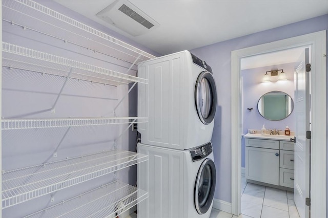 8 Dylans, Falmouth, MA 02536 - clothes washing area featuring stacked washing machine and dryer, baseboards, and light marble finish flooring