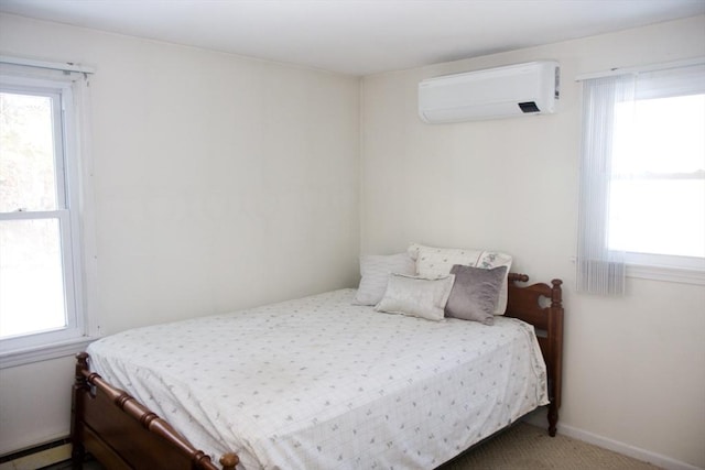 bedroom featuring a baseboard heating unit, an AC wall unit, and carpet floors