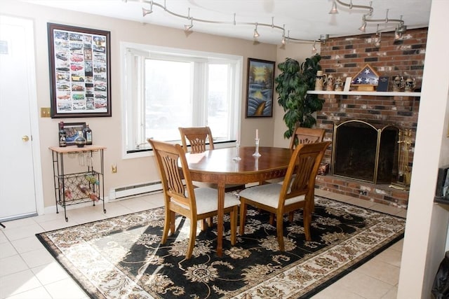 dining area featuring a fireplace, baseboard heating, track lighting, and tile patterned floors