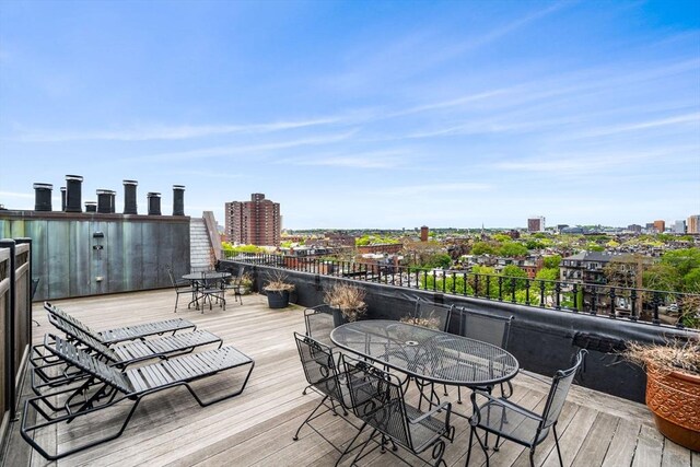wooden deck with outdoor dining space and a view of city
