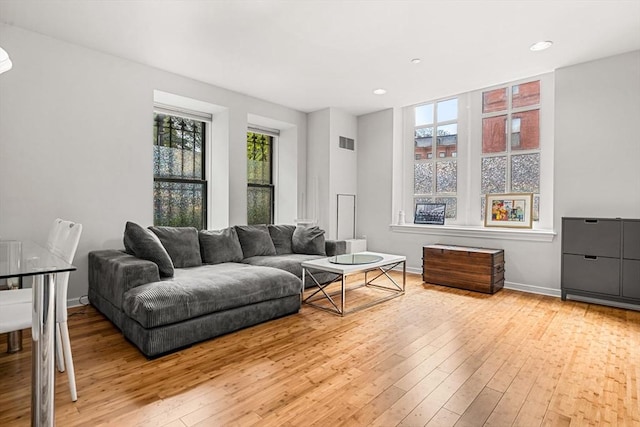 living room featuring hardwood / wood-style flooring, baseboards, and recessed lighting