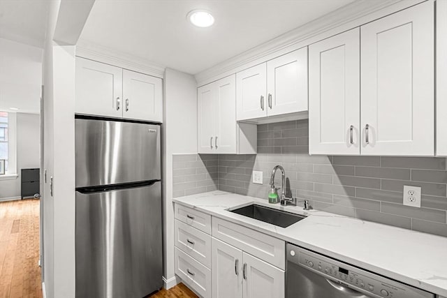 kitchen featuring stainless steel appliances, a sink, white cabinetry, and recessed lighting