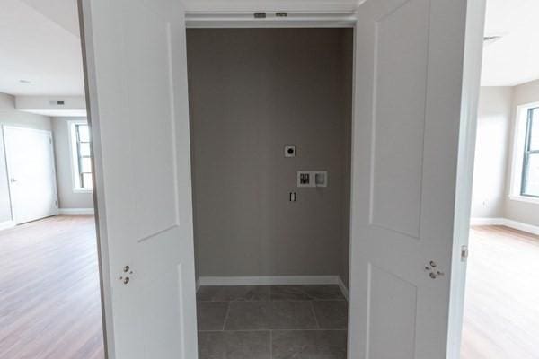 laundry area with hookup for a washing machine, plenty of natural light, hookup for an electric dryer, and tile patterned flooring