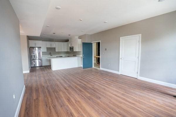 kitchen featuring light hardwood / wood-style floors, white cabinetry, appliances with stainless steel finishes, and a center island