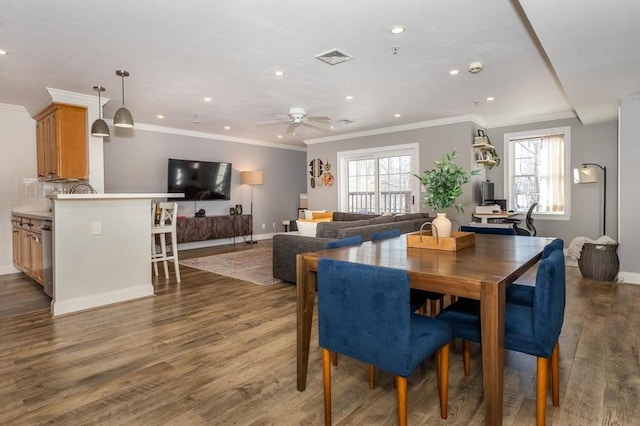 dining space featuring dark wood-type flooring, ceiling fan, and ornamental molding